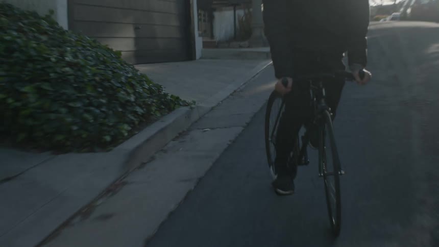 Person riding bike swerves side to side at sunset