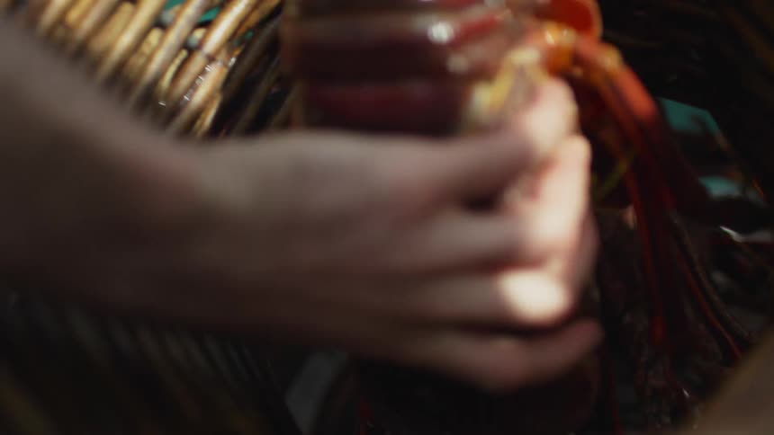 Hand picking up a live lobster from a wicker basket