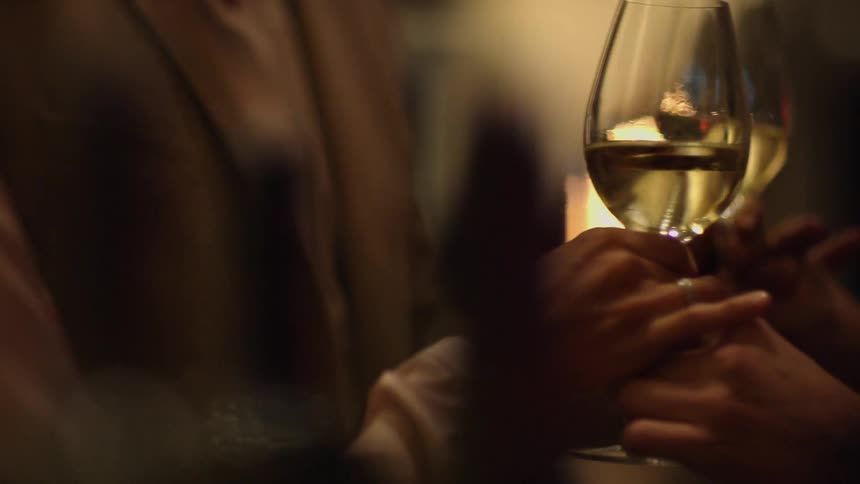 Two glasses of wine are served to two people