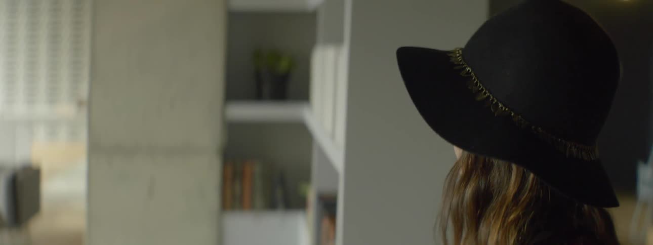 Woman wearing a hat looking around indoors