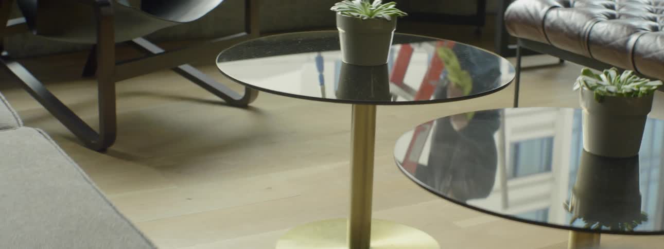 Person climbing a ladder as seen from a reflection  on a glass table