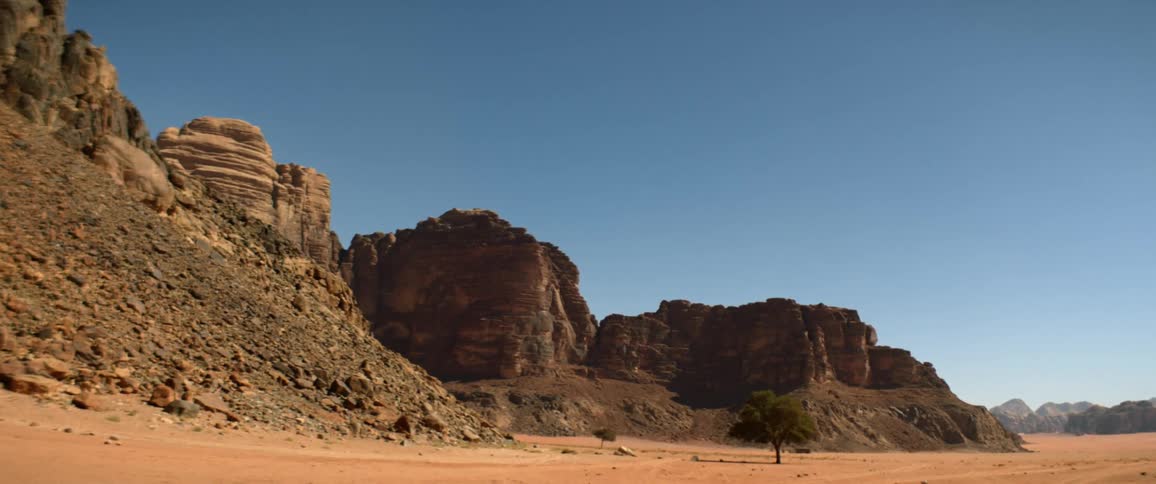 A landscape view of cliffs on sandy soil