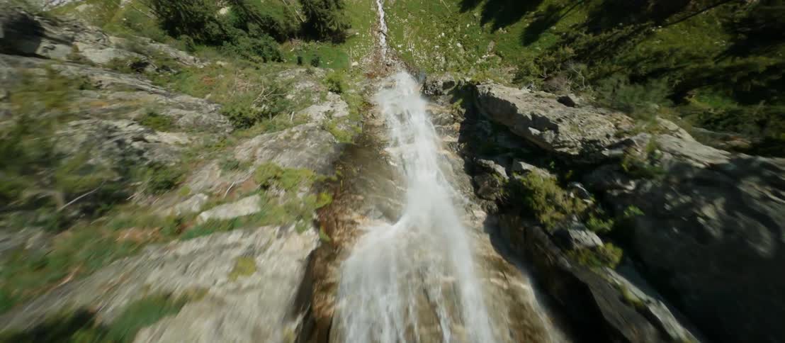 A river running down a rocky mountain slope on a sunny day