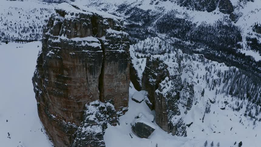 Snow covered mountains and rock formations under a cloudy sky