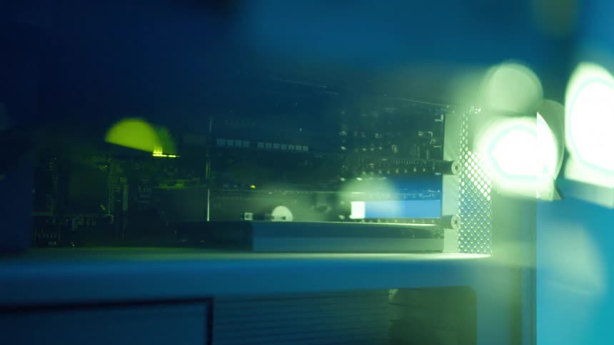 Close up of the interior components on a computer surrounded by changing colorful lights