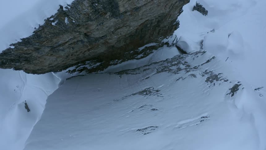 Snow coats cliff crevice and nearby plain
