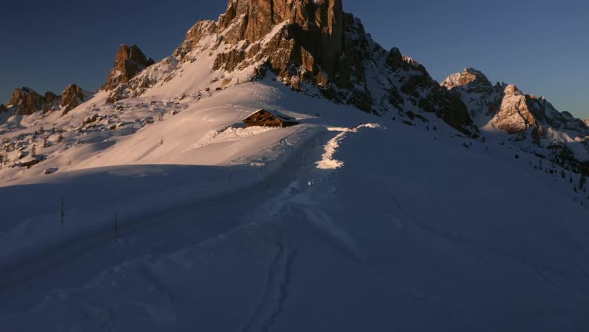 A mountain range covered in snow and ice with the sky and clouds in the background