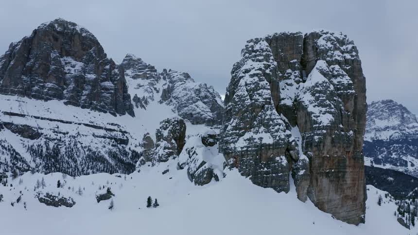 Snow covered mountains and forest under an overcast sky