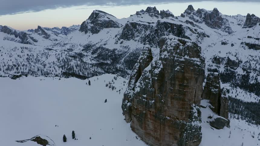 Aerial view of snow covered slopes on a mountain range at sunse