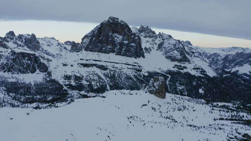 Snow covered mountain range with peaks high in a gray sky