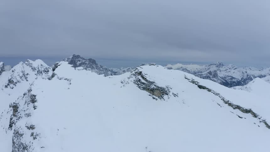 An aerial view of snowcovered mountains on an overcast day