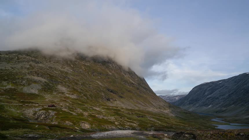 Clouds flow over the peak of the mountain range
