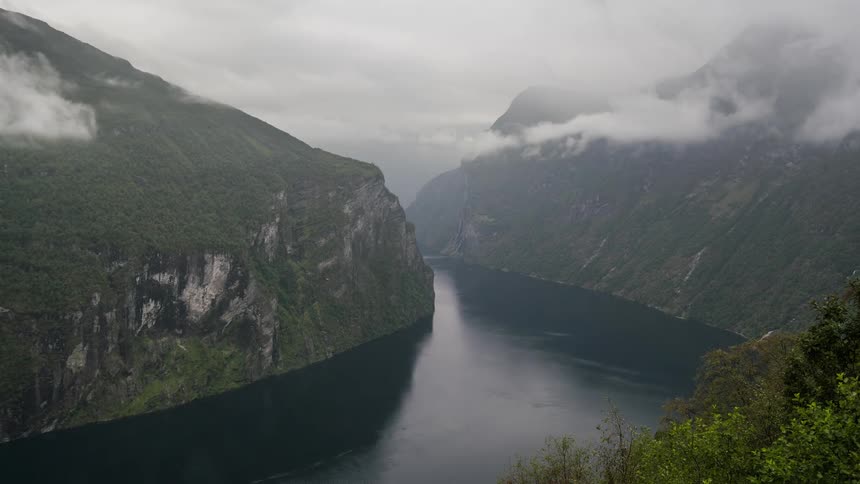 Time lapse of clouds moving over a river through the mountains