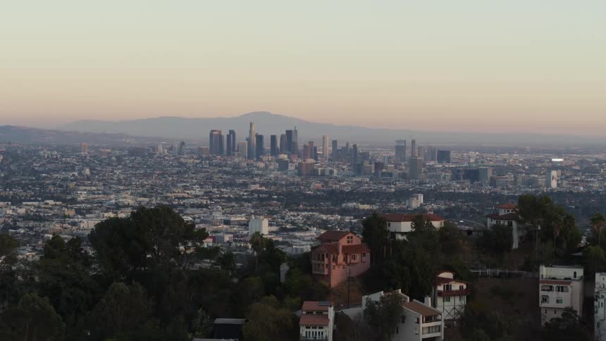 The camera flies slowly through Hollywood Hills towards Downtown Los Angeles