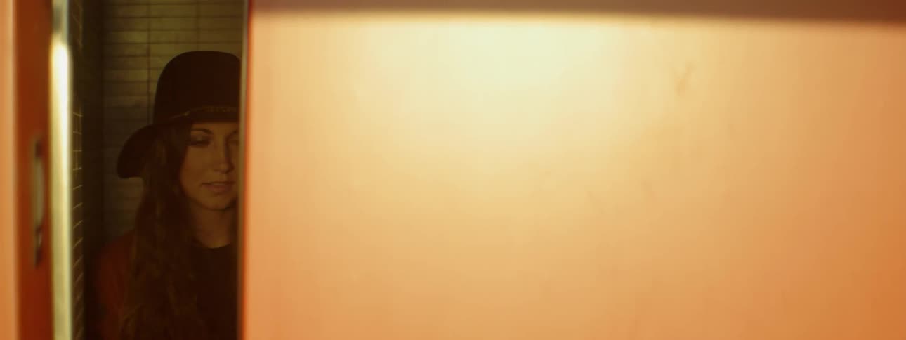 Woman in hat standing in elevator as the door closes