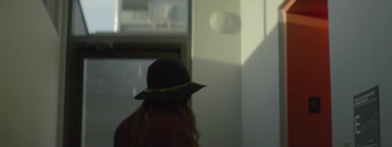 Woman in a hat walks into an elevator