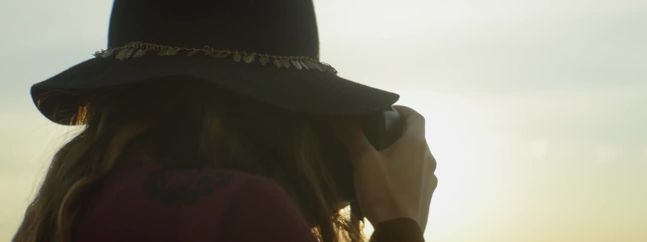 A woman takes photographs at sunset