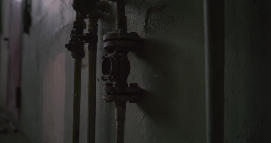 Old pipes and valves on a cement wall