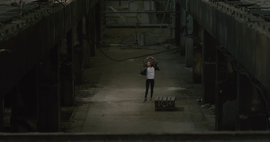 A woman in an abandoned building dancing