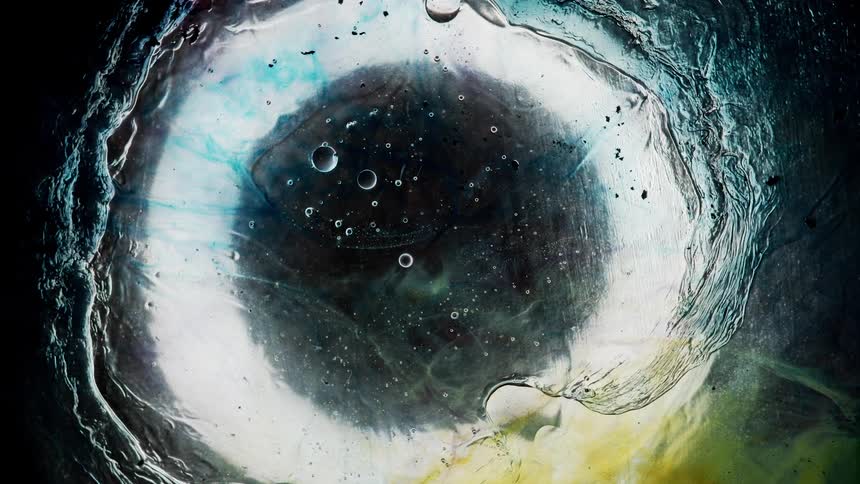Underwater footage of water and bubbles rippling under an sheet of ice