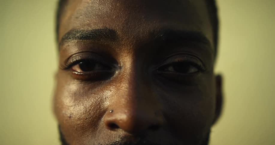 A close up of a man opening his eyes