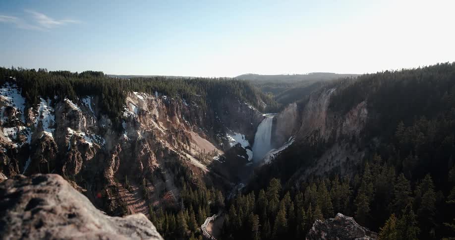 A waterfall into a canyon on a clear day