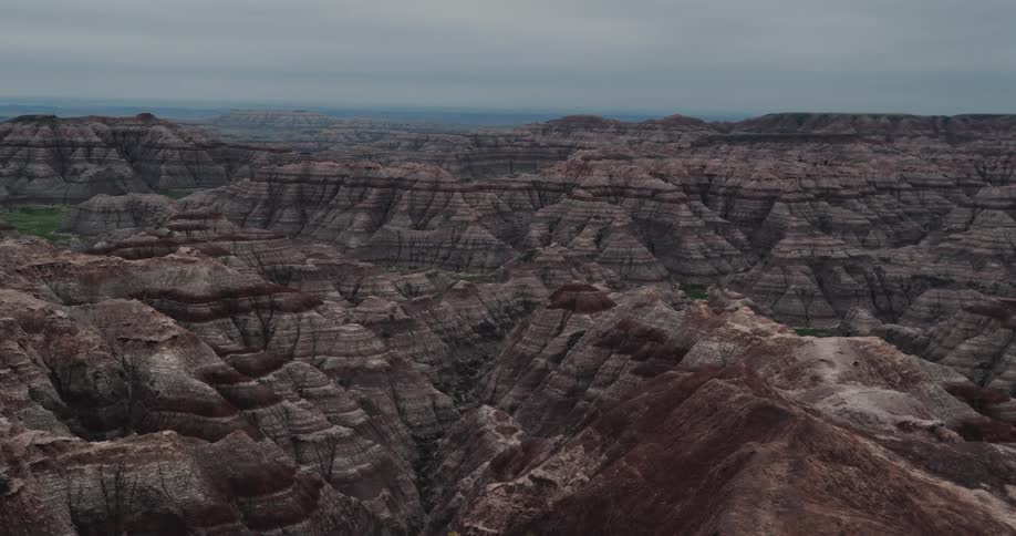 Aerial view of mountains and rock formations under a hazy sky