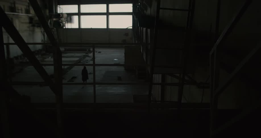 A person walking around in an abandoned warehouse