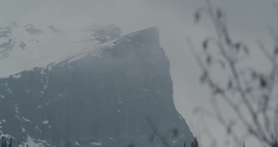 Heavy fog and snow cover the mountains