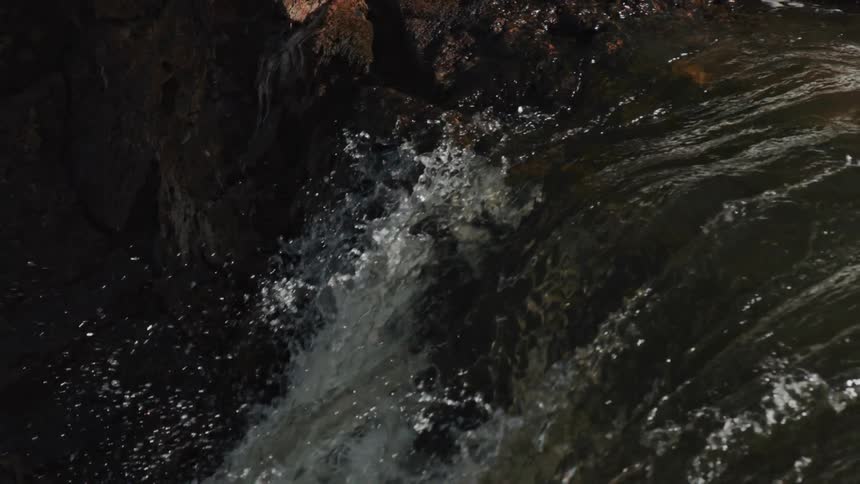 Clear water river flowing into a waterfall at evening