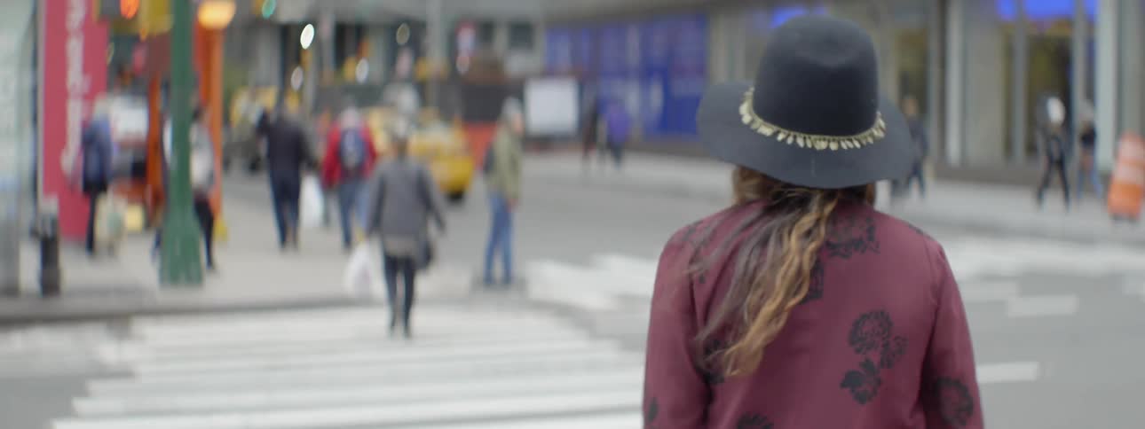 A woman in a purple shirt walks down the street