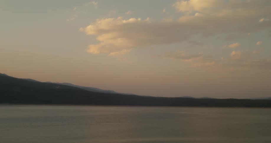 Mist covers shore and mountains on horizon