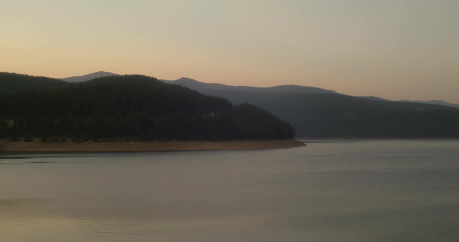 Silhouette of a mountain range close to the ocean at sunset