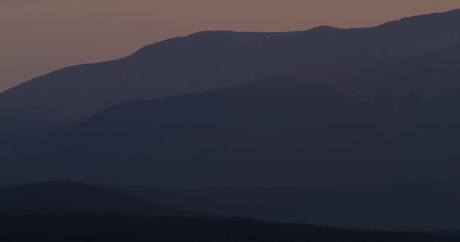 Fog is covering the mountain range at dusk
