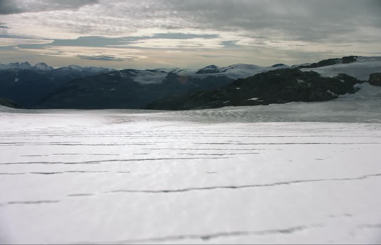 Aerial view of snow covered field with distant mountain ranges