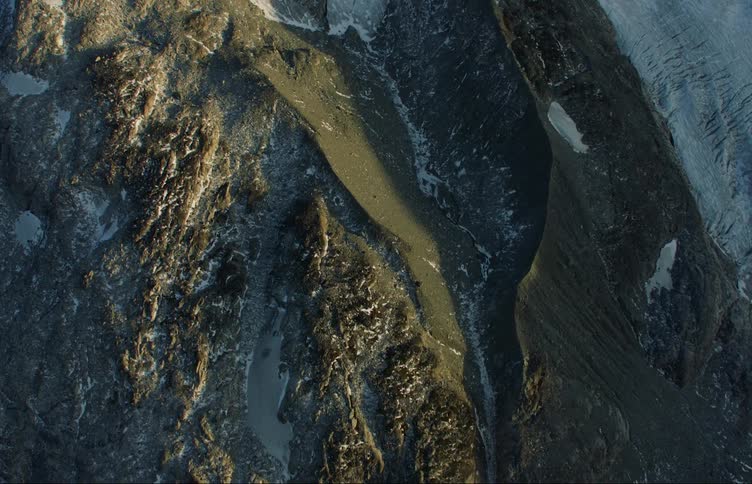 Snow and ice occupy valleys as parts of mountains sit in shadow