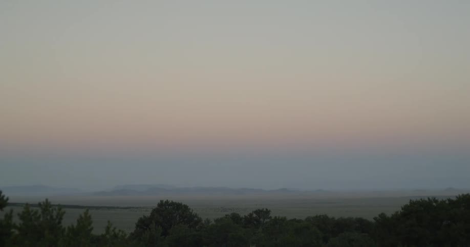 Sunrise causes the sky to glow where it meets the sea on the horizon