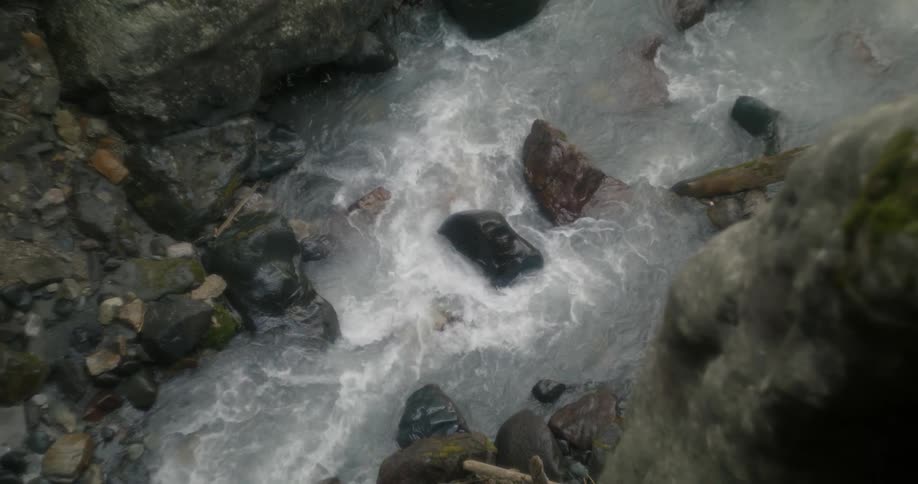 River water swirls and flows around stone in a canyon