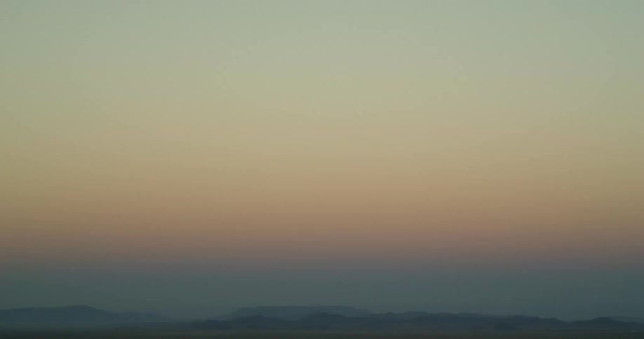 Silhouette of a mountain range under the mist at sunset