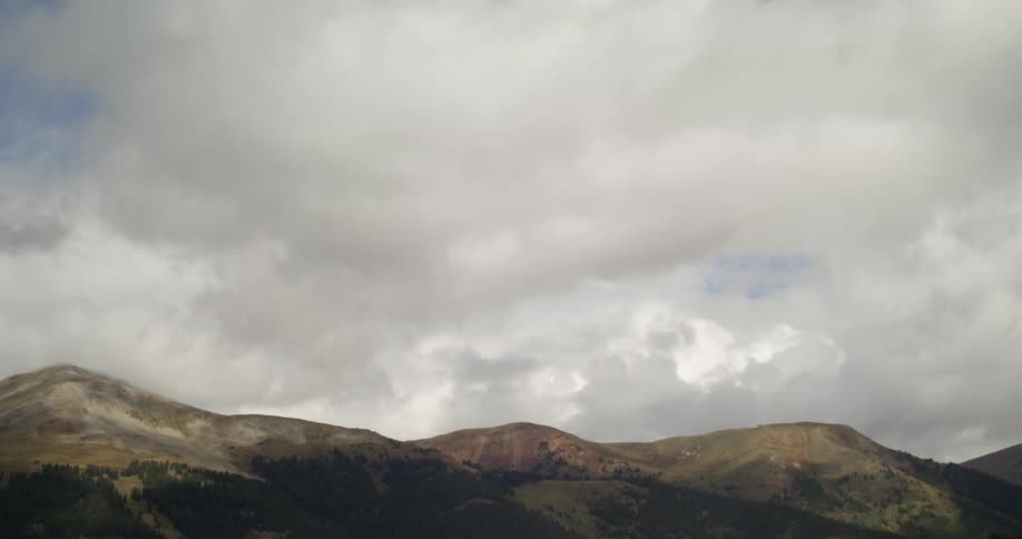 White clouds rolling over the slopes of a mountain at morning