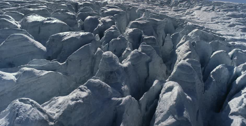 Shadowy crevices and brighter peaks stretch across glacier