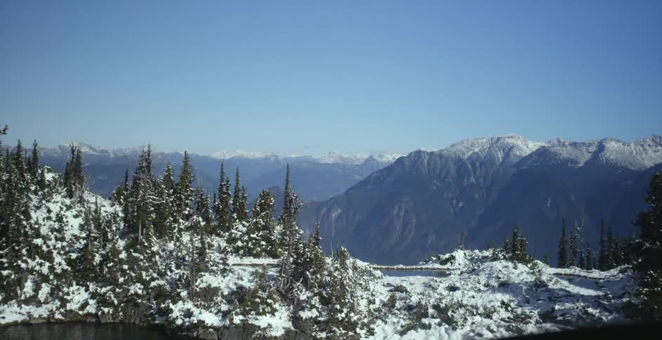Aerial view of a lake on the snow covered top of a mountain range at daytime