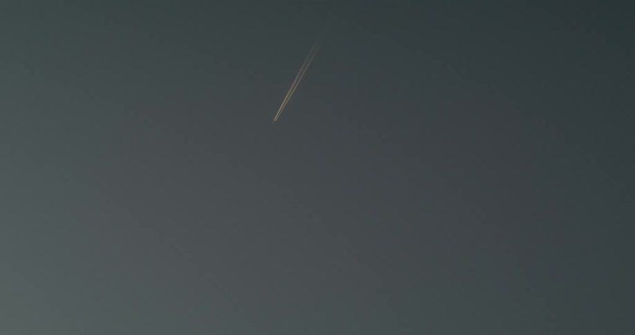 A plane flying past an otherwise empty sky
