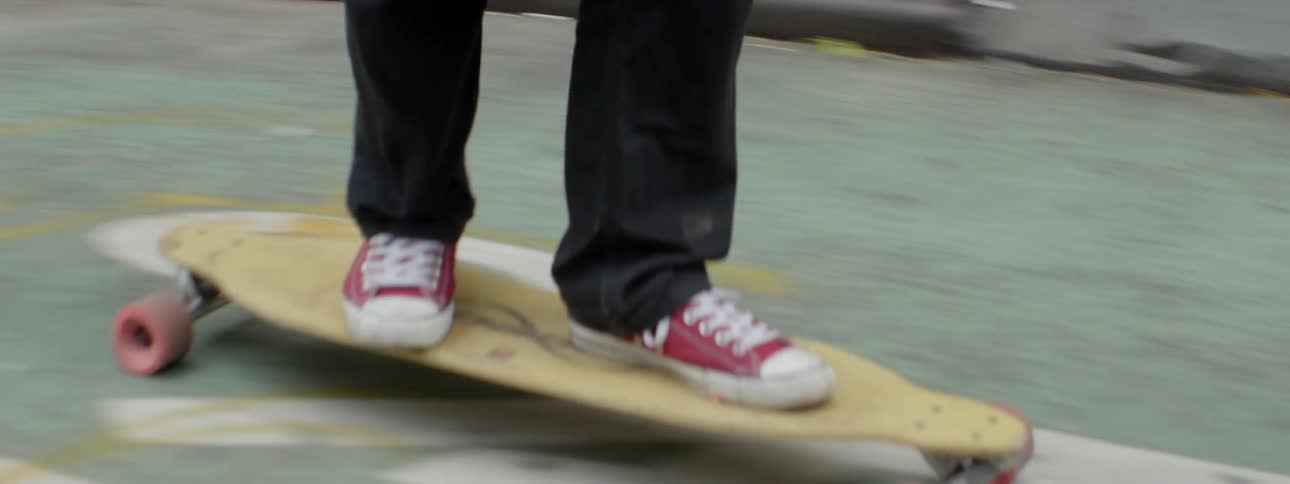 Person rides down a street on a longboard