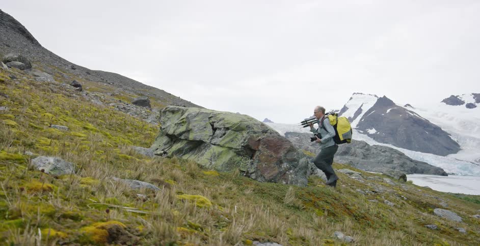A man hikes up a rocky hill