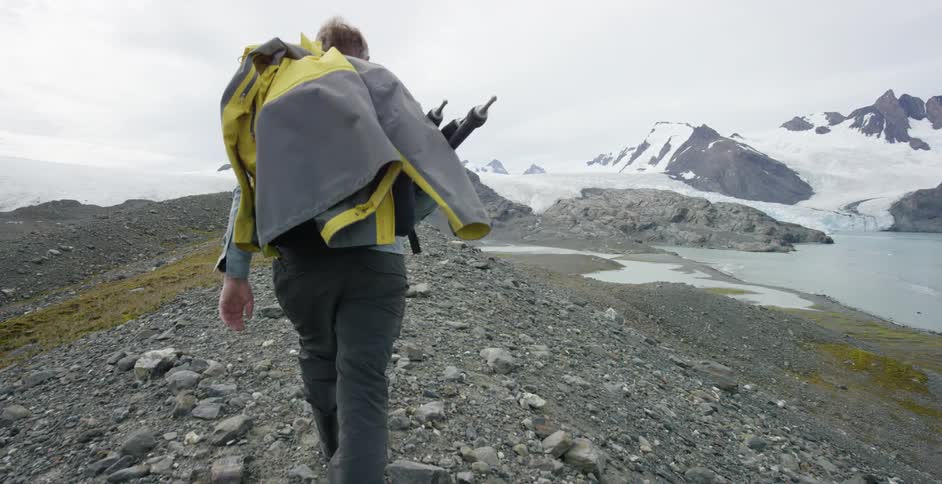 A man hikes up a gravelly hill