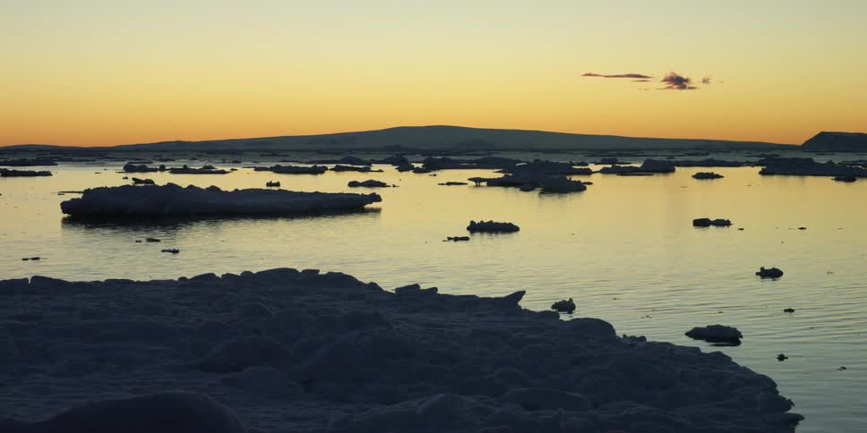 A body of water with small islands in it at sunset