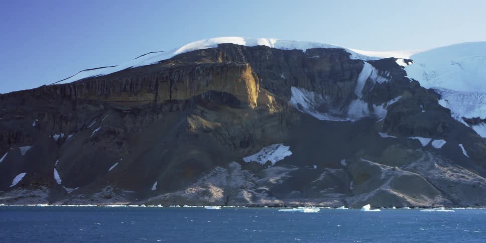 Ice floats along the shore of this mountain