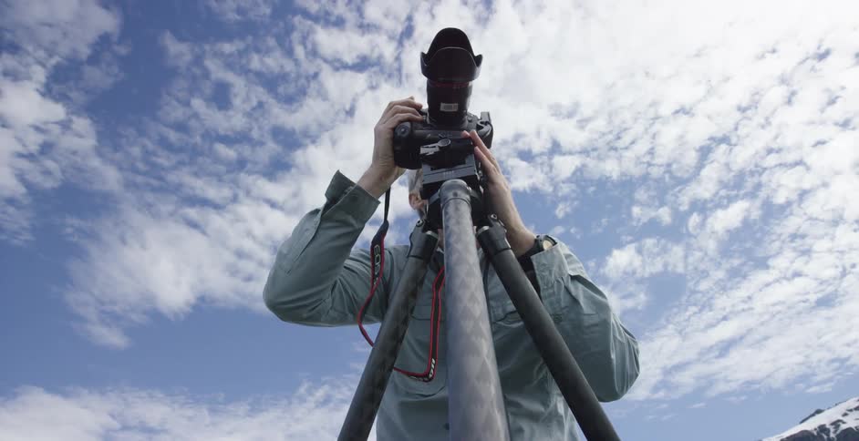 A person adjusts a camera outdoors