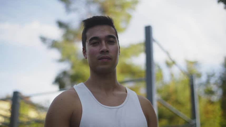 Young muscular man wearing a white undershirt looking at the camera